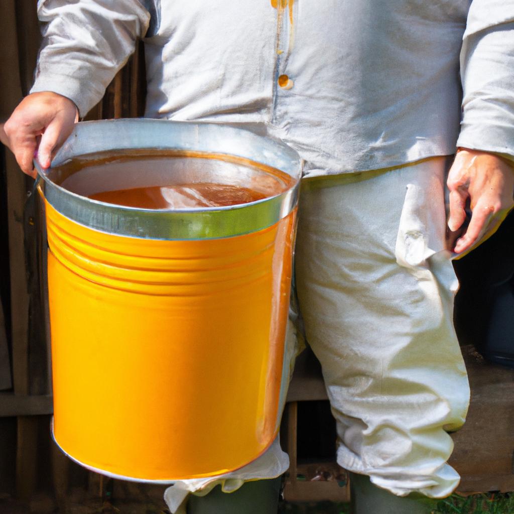 A beekeeper holding a 5-gallon bucket of honey after harvesting it from their hive.