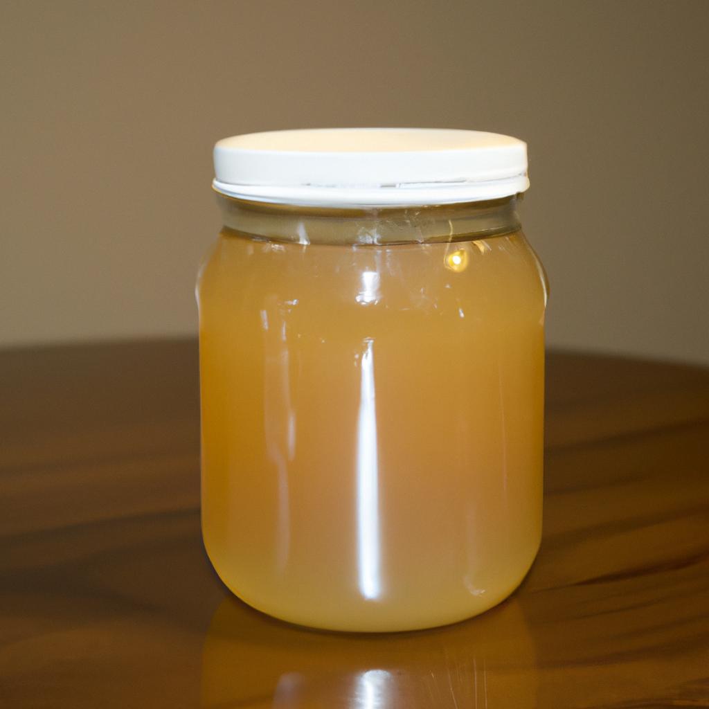 An up-close shot of a 16 oz jar of honey on a wooden table