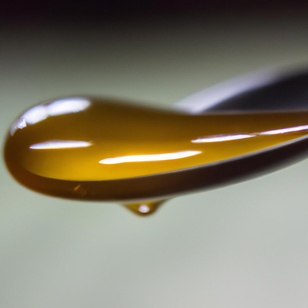 A close-up shot of a single drop of honey, a product of hardworking bees.